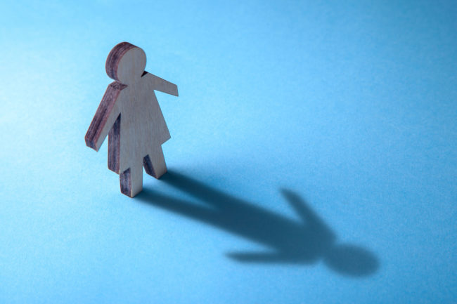 Figura femenina refleja con su sombra figura masculina